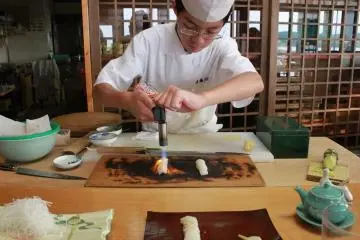 Motoshige searing the top of the fish with a torch.&nbsp; (Photo: Stephanie Fiorello)