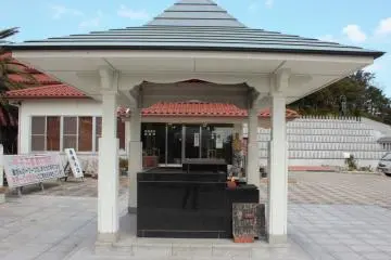 An offertory box and incense altar in front of the shop.  The red roofed shop sells the entrance tickets as well as souvenirs and religious items. (Photo: Bret de Colebi)