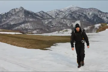 The author trekking with his paraglider on Heidi Hill in spring (Photo: Satomi Boasen)