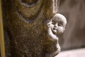 The babe at the foot of a Jizo statue (Photo: <a href="http://www.gethiroshima.com" target="_blank" rel="noreferrer noopener nofollow">gethiroshima</a>)