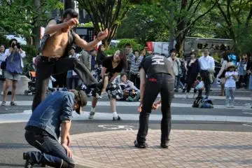 The crowd is entertained as one of the dancers hurdles over some of the other members on the floor