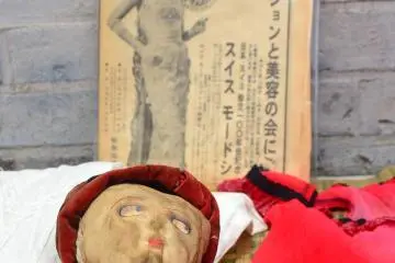 An old baby doll averts her eyes from the camera.