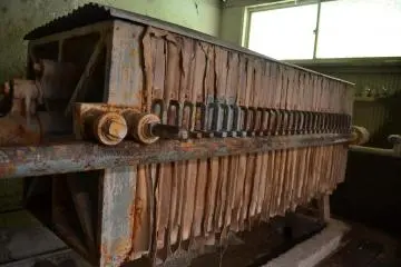 A press used to extract water from the filtered clay, producing clay sheets.