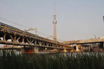 The train tracks cross the river in parallel to the Azumabashi Brudge.