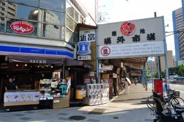 Sushi Okame is just by the entrance to Outer Market (Photo: <a href="https://ja.wikipedia.org/wiki/%E3%83%95%E3%82%A1%E3%82%A4%E3%83%AB:Tsukiji_fish_market-1.jpg" target="_blank" rel="noreferrer noopener nofollow">江戸村のとくぞう</a> / <a href="https://creativecommons.org/licenses/by-sa/4.0/deed.en" target="_blank" rel="noreferrer noopener nofollow">CC BY-SA 4.0</a>)