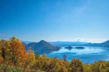 Lake Toya against the autumn leaves (Photo: chatnara / Shutterstock.com)