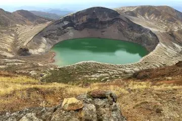 The emerald green of Okama Crater (Photo: <a href="https://commons.wikimedia.org/wiki/File:Okama_crater_lake,_Mt._Zao,_Tohoku_region,_Japan_(north_facing_view).jpg" target="_blank" rel="noreferrer noopener nofollow">OKJaguar</a> / <a href="https://creativecommons.org/licenses/by-sa/4.0/deed.en" target="_blank" rel="noreferrer noopener nofollow">CC BY-SA 4.0</a>)