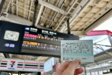 Holding up a Shinkansen ticket (Photo: Applepy / Shutterstock.com)